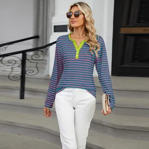 Detailed view of women's V-neck striped long sleeve T-shirt in urban street setting