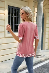 Vista posteriore di una t-shirt rosa da donna con bordo leopardato su maniche e orlo.