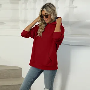 Stylish casual red hooded sweatshirt with front pocket, modeled in an architectural setting