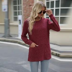 Detail of burgundy ribbed long sleeve top featuring practical pockets and stylish puff sleeves