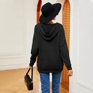 Vista trasera de una sudadera con capucha negra texturizada con jeans azules