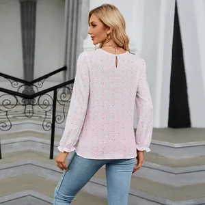 Detailed back view of a woman wearing a casual long-sleeved floral top with crew neck and ruffles.
