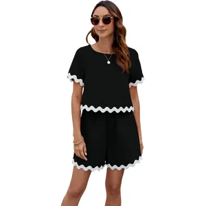 Stylish black two-piece set with white scalloped trim, featuring short sleeves and shorts.