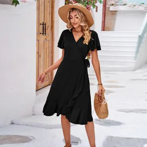 Detail of black V-neck wrap dress with ruffled irregular hem for summer