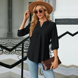 Vista detallada de la elegante blusa negra de mujer con cuello en V y mangas tres cuartos