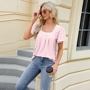 Outdoor street style shot of a woman in a pink eyelet square neck short sleeve top