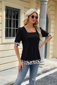 Dettaglio di una t-shirt nera con scollo quadrato e maniche a sbuffo leopardate.