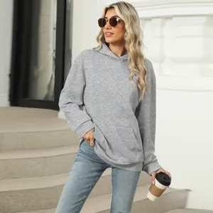 Detailed view of a casual grey hooded sweatshirt with a front pocket styled with blue jeans
