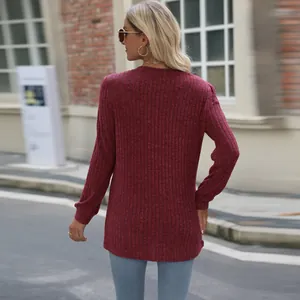 Back view of a burgundy ribbed knit long sleeve top with puff sleeves in an urban setting.