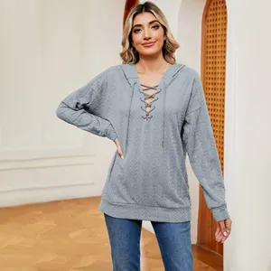 Detalle de una sudadera con capucha gris con textura y un elegante escote con cordones