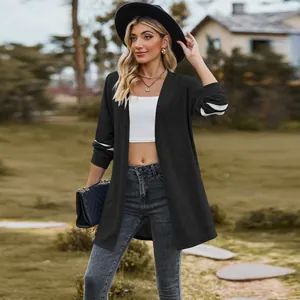 Long sleeve black knit cardigan with white sleeve stripes shown in outdoor street style