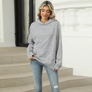 Front view of a women's casual grey hooded sweatshirt with pocket detail on stairs