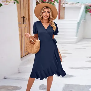 Detailed outdoor view of a navy blue V-neck wrap dress with ruffled hem and tie waist
