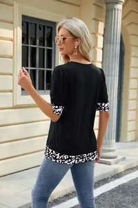 Vista posteriore di t-shirt nera da donna con dettagli in stampa animalier su orli.