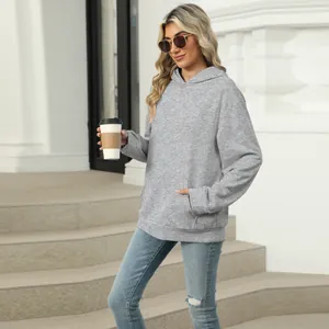 Casual grey oversized hoodie with pocket in a stylish lifestyle outdoor urban street view.