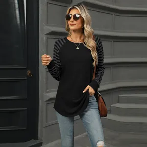 Casual women's round neck T-shirt featuring black body and striped patchwork long sleeves.
