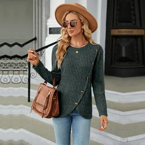 Detailed view of long sleeve knit top with decorative side buttons and tulip hem