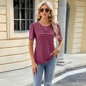 Detailed view of a burgundy pleated short sleeve t-shirt with U-neck in outdoor setting