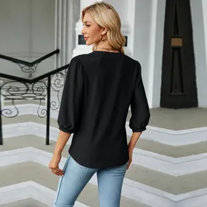Detalle de la espalda de una blusa negra con cuello en V y mangas abullonadas 3/4