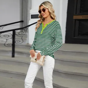 Detailed street style view of a woman wearing a green striped V-neck long sleeve T-shirt