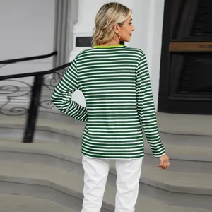 Back view of a casual green and white striped long sleeve women's t-shirt outdoors.