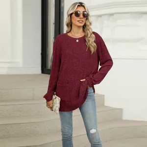 Detailed view of burgundy ribbed long-sleeve knit top with pocket and round neck.