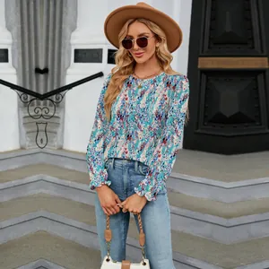 Detailed shot of bohemian floral print blouse featuring ruffled cuffs on model outdoors