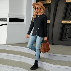 Outdoor street style shot of a black ribbed long-sleeve top with tulip hem detail