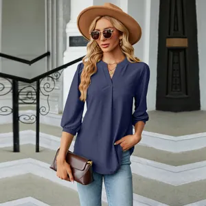 Elegante blusa azul marino con cuello en V, motivo jacquard y manga tres cuartos.