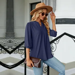 Blusa de jacquard azul marino con cuello en V y manga 3/4 en modelo en entorno exterior