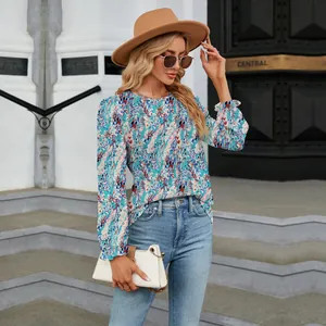 Close-up of floral print long sleeve blouse styled with blue jeans and a hat