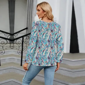 Back view of floral print long sleeve top featuring round neck and back button closure