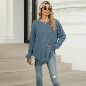 Casual blue ribbed knit top with pocket and crew neck worn by a model on stone steps