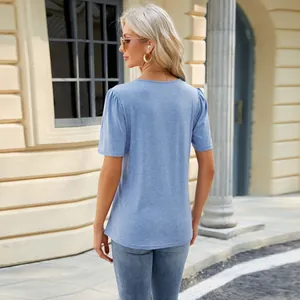 Rear view of a women's light blue pleated short-sleeve T-shirt in urban setting