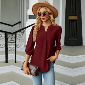 Detalle de blusa de jacquard burdeos con cuello en V y mangas 3/4 de mujer