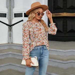 Detailed view of floral print long sleeve top with ruffled cuffs on model