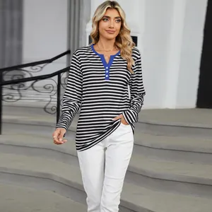 Detail view of the blue contrast V-neck and black striped pattern on a loose long sleeve top.
