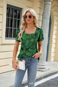 Detail view of women's square neck petal sleeve top with green tropical leaf print