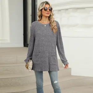 Model wearing casual grey ribbed long sleeve tunic with pockets and round neck