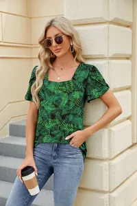 Detail view of a green tropical leaf print T-shirt with square neck and petal sleeves.