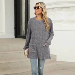 Close-up of a grey ribbed knit top with two functional front pockets and a round neck