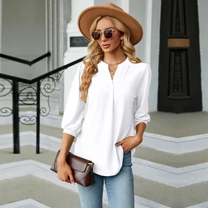 Detalle de blusa de jacquard blanca con cuello en V, elegantes mangas 3/4 y corte holgado