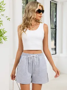 Detailed view showing the styling of white crop tank top and grey athletic drawstring shorts