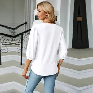 Vista trasera de una blusa de jacquard blanca con cuello en V y mangas abullonadas 3/4