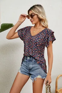 Side view of woman in floral V-neck T-shirt with ruffle sleeves and denim shorts