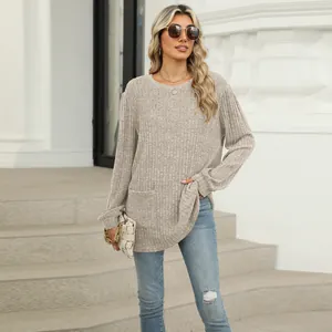 Detail view of a beige rib-knit long sleeve top with a functional pocket and relaxed fit