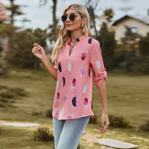 Detailed view of women's pink V-neck loose shirt featuring a colorful feather print design.
