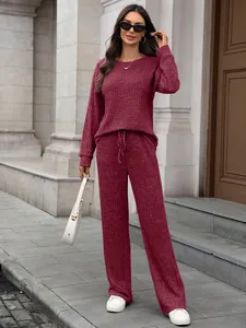 A detailed view of a stylish maroon ribbed knit loungewear set featuring wide-leg pants.