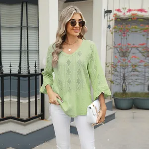 Close-up detail of a light green hollow jacquard V-neck top featuring elegant bell sleeves