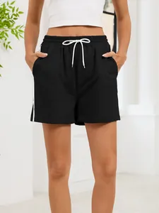 Front view detail of women's black athletic casual shorts with side stripes and drawstring